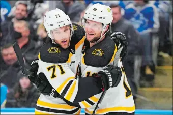  ?? FRANK GUNN/THE CANADIAN PRESS/AP PHOTO ?? Boston Bruins’ Pavel Zacha (18) celebrates his goal against the Toronto Maple Leafs with teammate Taylor Hall (71) during the third period of an NHL game on Feb. 1 in Toronto.