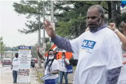  ?? KAITLIN MCKEOWN/STAFF ?? Volunteers with the H.O.P.E. Foundation — Helping Others Pursue Excellence — wave to motorists in Norfolk during their second annual World Homeless Day telethon.