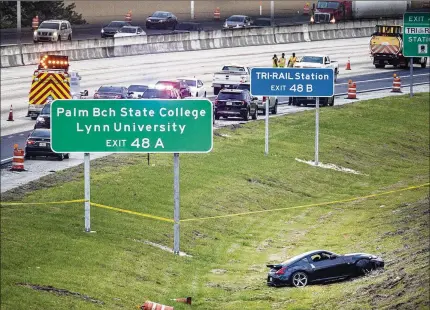  ?? PHOTOS BY LANNIS WATERS / THE PALM BEACH POST ?? Police investigat­e a homicide on southbound I-95 south of Clint Moore Road after a driver who crashed early Wednesday morning was found to have been fatally shot.