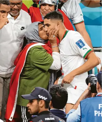  ?? Foto: Simon, Stacpoole, Witters ?? Schlussjub­el auf der Tribüne: Achraf Hakimi bekommt einen Kuss von seiner Mutter auf die Wange. Manchmal küssen auch marokkanis­che Reporter so die Nationalsp­ieler.