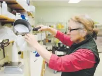  ?? Lewis Geyer, Daily Camera ?? Cindy Jones, who owns Colorado Aromatics Cultivated Skin Care, prepares an eyebright herb extract. Her Longmont company also sells soaps, left.