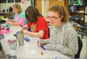  ??  ?? From left, students Hailey Morris, Jessica Rodella and Tatum Mixon create labels for K9 Crackers at Cabot High School. The business offers community-based instructio­n students the opportunit­y to learn life skills.