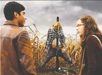  ?? EONE FILMS ?? Michael Garza, left, and Zoe Margaret Colletti confront Harold the scarecrow in the new movie Scary Stories to Tell in the Dark.