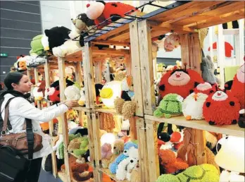  ?? XINHUA JIANG DONG /CHINA DAILY ?? A child looks at a Hello Kitty during a toy exhibition organized by McDonald’s Corp in Beijing. A buyer picks toys at an industry expo in Hong Kong.