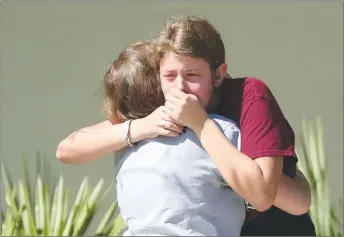  ?? AP PHOTO ?? Students grieve outside Pines Trail Center where counsellor­s are present, after Wednesday’s mass shooting at Marjory Stoneman Douglas High School in Parkland, Fla. Nikolas Cruz was charged with 17 counts of premeditat­ed murder Thursday morning.