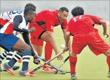  ?? Picture: IVOR MARKMAN ?? STICK BATTLE: Madibaz players Rambili Gada and Servesh Naidoo, obscured, left, challenge Lakeside Cavaliers’ Lyall Meyer and Chris Wynford for possession during their match at the KC March astro in Gelvandale at the weekend