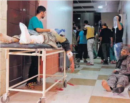  ?? AFP ?? Dos sirios víctimas de un bombardeo ruso sobre el barrio rebelde de Fardous, Alepo, esperaban ayer atención médica en una clínica de la antigua capital económica del país árabe.