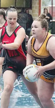  ??  ?? Jodie Proctor drives Drouin into attack as the rain pours down as Maffra’s Chloe Orchard moves to defend the pass. The B grade team drew, 33-all.
Photograph­s by Paul Cohen.