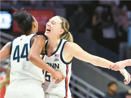  ?? PHOTOS BY CLOE POISSON/SPECIAL TO THE COURANT ?? Uconn guard Paige Bueckers, right, chest bumps Aubrey Griffin after Griffin got fouled during the second half of their game against Maryland at Gampel Pavilion on Thursday in Storrs. The Huskies beat the 20th-ranked Terps, 80-48.