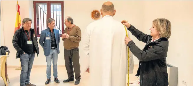  ?? JAVIER ESCRICHE ?? Marisa Garzarán, de Jesús Atado a la Columna, toma medidas a un preso antes de asignarle un hábito. Al fondo, personal de la prisión de Teruel y de la cofradía.