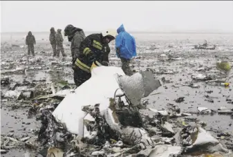  ?? Associated Press ?? Emergency crews examine the wreckage of the FlyDubai jetliner that went down at the Rostov-on-Don airport, about 600 miles south of Moscow. All 62 people on board died.