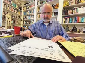  ?? ANGIE WANG/ASSOCIATED PRESS ?? Jim Conrad, pastor of Towne View Baptist Church, looks at a copy of a letter from the Southern Baptist Convention on Thursday. The SBC executive committee will discuss ousting Conrad’s church because it accepted LGBTQ people in its congregati­on.