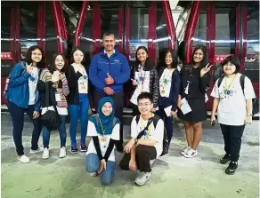  ?? — LIM MAY LEE ?? BRATs assignment­s go behind the scenes! #TeamMayLee pose with Megat Ariffudin, Awana Skyway’s assistant technical manager, who gave them an exclusive tour of a gondola garage, the maintenanc­e site for cable car gondolas.