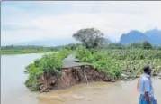  ?? PTI ?? ▪ A man surveys a road washed out due to the floods following heavy rainfall caused by cyclone Ockhi in Kanyakumar­i on Saturday. The cyclone has claimed 22 lives in Kerala and Tamil Nadu so far.