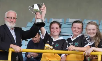  ??  ?? Kevin Waters of the Rackard League presents the trophy to Ballyroebu­ck captain Rebecca Kavanagh.