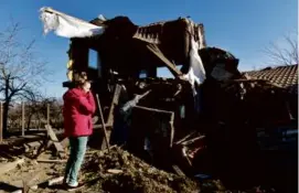  ?? AFP VIA GETTY IMAGES ?? A woman stood outside her house in Uglegorsk in Ukraine’s Donetsk region Thursday following recent shelling.