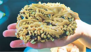  ?? AMY DREW THOMPSON/ORLANDO SENTINEL ?? This one may be more your style: Shaka Donuts’ Orlando Mayor Buddy Dyer’s “Nutty Buddy,” which features chocolate icing, crushed peanuts and a decadent dousing of peanut butter drizzle.