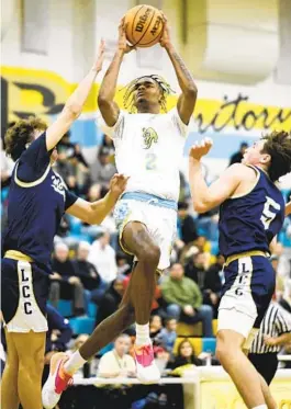  ?? DENIS POROY FOR THE U-T ?? San Ysidro’s JJ Taylor flies past La Costa Canyon’s Ty Hendler (left) and Parker Jelsing during Open division playoff game Friday won by San Ysidro.