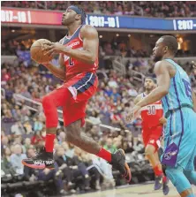  ?? AP PHOTO ?? NICE TO HAVE YOU BACK: John Wall (left) scores two of his 15 points in the Wizards’ 107-93 win against Charlotte yesterday.