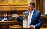  ?? ARVIN TEMKAR / ARVIN.TEMKAR@AJC.COM ?? State Sen. Steve Gooch, R-dahlonega, holds a road sample while speaking in support of HB 189 on Thursday.