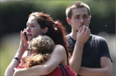  ?? ANDREW NELLES — THE TENNESSEAN VIA AP ?? Kaitlyn Adams, a member of the Burnette Chapel Church of Christ, hugs another church member at the scene after shots were fired at the church on Sunday in Antioch, Tenn.