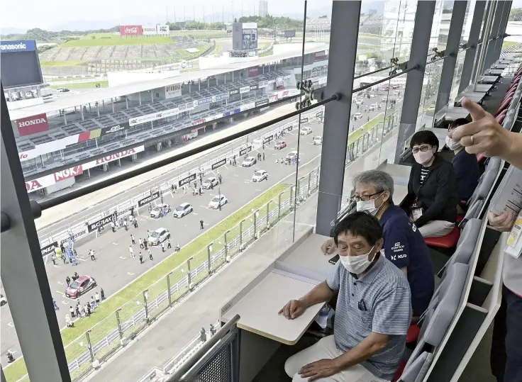  ?? ?? Yomiuri Shimbun photos
Above:Yoshishige Nakano, right, shows Suzuka Circuit’s attraction­s to participan­ts on a tour of the facility on June 19 in Suzuka, Mie Prefecture.
Below: Participan­ts tour the track and check a hairpin turn at Suzuka Circuit.