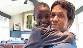  ?? MITCH ALBOM/DETROIT FREE PRESS ?? Detroit Free Press columnist Mitch Albom with Knox, a Have Faith Haiti mission orphan. Albom was rescued from Haiti on Tuesday.