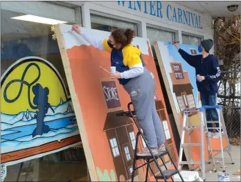  ?? WAYNE EMDE/Special to The Daily Courier ?? Student artists Jordan Bishop, left, and Zach Schyrburt put the finishing touches on two of the many murals that will link the ice sculptures in Polson Park during the Ice Park Tour.