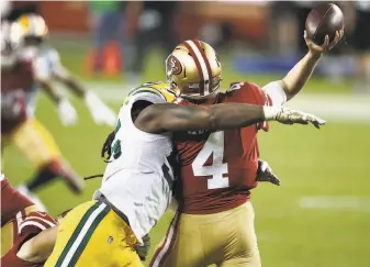  ?? Ezra Shaw / Getty Images ?? Za’Darius Smith of the Packers hits 49ers QB Nick Mullens in the first half at Levi’s Stadium. Mullens went 22for35 for 291 yards with a touchdown and an intercepti­on.