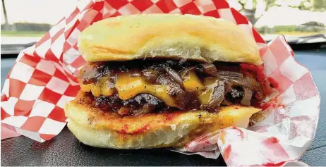  ?? Alison Cook/Staff ?? A 5-ounce grilled cheddar cheeseburg­er with sautéed onions, kimchi relish and sambal mayo is available at Burger Chan.