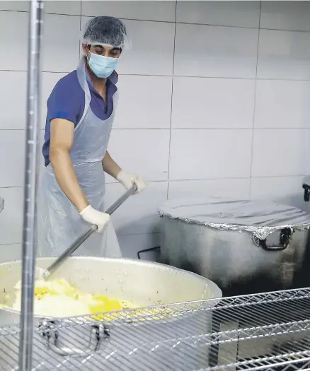  ?? Photos Pawan Singh / The National ?? Al Nadeg restaurant preparing food for a labour camp in Al Muhaisnah, Dubai, last year. Campaigns such as 100 Million Meals, left, are involved in food drives this year