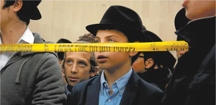  ??  ?? Boys outside the Tree of Life synagogue in Pittsburgh, Pennsylvan­ia, following the shooting on October 27.