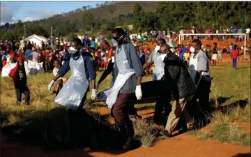  ??  ?? Rescues carry a dead body after Cyclone Adai at Ngangu suburb in Chimaniman­i, Zimbabwe.