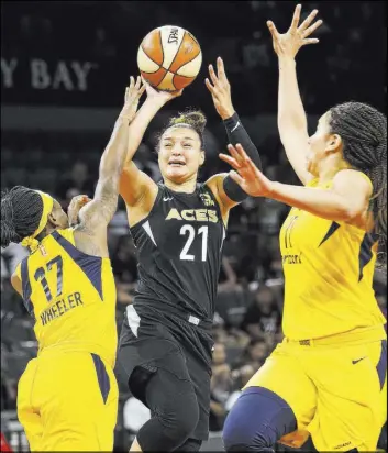  ?? Richard Brian Las Vegas Review-Journal @vegasphoto­graph ?? Aces guard Kayla McBride shoots through Indiana Fever guard Erica Wheeler (17) and forward Natalie Achonwa (11) in the first half of a 92-74 WNBA victory Saturday at Mandalay Bay Events Center.