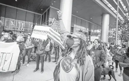  ?? Photos by Steve Gonzales / Staff photograph­er ?? Tracy Daniel chants with other protesters and activist organizati­ons at a rally in front of the Greater Houston Partnershi­p building to demand the business group oppose voting restrictio­ns.