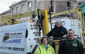  ??  ?? Plans Taking down the Braemar Day banner are Kathryn McLagan from the Blairgowri­e and Rattray Braemar Associatio­n committee (centre) and Jackie Dennis and Tam Beattie from TJB Landscapes