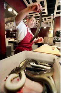  ??  ?? Chef Masa Miyake prepares to clean and cook eels at his Japanese restaurant, in Portland, Maine.