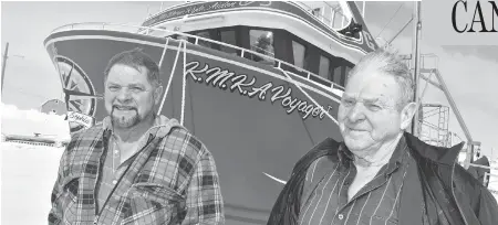  ?? AARON BESWICK PHOTO ?? Theodore Genge and his father Rufus in front of the KMKA Voyager in Anchor Point, N.L. The shrimp dragger’s 914-hp engine is powerful enough to haul two trawls the 400 nautical miles from the shrimp grounds, but those stocks are beginning to collapse,...