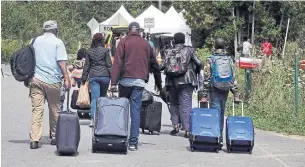  ?? CHARLES KRUPA THE ASSOCIATED PRESS FILE PHOTO ?? A family from Haiti, coming from New York state, approach a tent in Quebec in 2017. Advocates say the Ontario government fuelled anti-refugee sentiment by presenting misleading informatio­n.