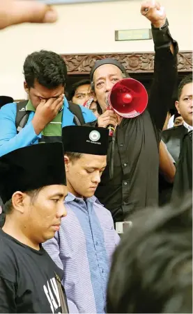  ?? CHUSNUL CAHYADI/JAWA POS ?? TETAP BEBAS: Abdul Wahab (memegang megafon) berbicara di hadapan ratusan simpatisan yang hadir dalam sidang di Pengadilan Negeri (PN) Gresik kemarin.