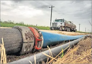  ?? [OKLAHOMAN ARCHIVES] ?? Temporary lines used to pump both fresh water and treated, produced water to a Kingfisher County well site is pictured in July.