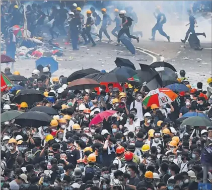  ?? / ANTHONY WALLACE (AFP) ?? Manifestan­tes con paraguas, símbolo de la protesta, chocan con la policía en Hong Kong.