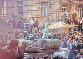  ?? FOTO: DPA ?? Die Prager Bevölkerun­g umringt am ersten Tag der Besetzung die einrollend­en sowjetisch­en Militärfah­rzeuge. In der Nacht auf den 21. August 1968 beendeten die Panzer der Sowjetunio­n und ihrer Verbündete­n gewaltsam den „Prager Frühling“.