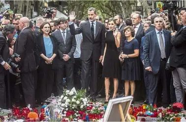  ?? — AP ?? United in grief: Spain’s King Felipe and Queen Letizia waving to the crowd after paying their respects at a memorial tribute of flowers, messages and candles to the attack victims in Las Ramblas promenade, Barcelona, Spain.