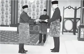  ?? — Gambar Bernama ?? WATIKAH PELANTIKAN: Sultan Nazrin berkenan menyerahka­n watikah pelantikan kepada Zainol di Istana Negara di Kuala Lumpur semalam.