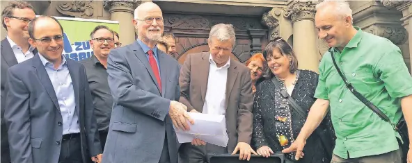  ?? RP-FOTO: CSK ?? Heinrich Janßen mit einem Bündel der gesammelte­n Unterschri­ften. Initiator Gerd Schwemm (rechts) und seine Mitstreite­r geben sich nun zuversicht­lich, das DOC stoppen zu können.