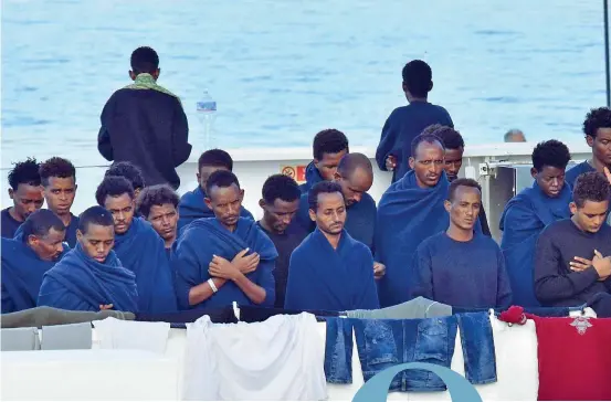  ?? (Ansa) ?? In mare Migranti in preghiera in attesa di sbarcare dalla nave della Guardia costiera Diciotti nel porto di Catania