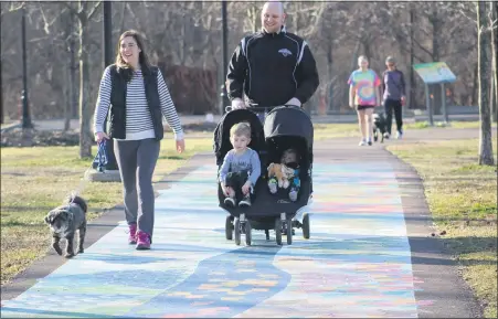  ??  ?? A family walks along the Schuylkill River Trail art mural at Pottstown Riverfront Park. Communitym­emberswill­walk along a 1-mile loop of the trail at the park for a Medicine on the Move program.