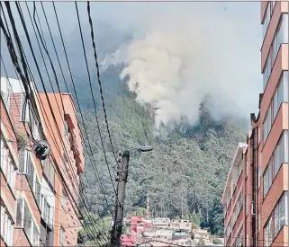  ?? EFE ?? Una gran columna de humo se eleva sobre la montaña debido a un incendio forestal en un sector de los cerros orientales en Bogotá.