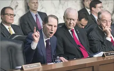  ?? J. Scott Applewhite Associated Press ?? SEN. RON WYDEN of Oregon, the top Democrat on the Senate Finance Committee, discusses the Republican tax bill this week. Democrats criticized the effort to add a healthcare provision to the legislatio­n.